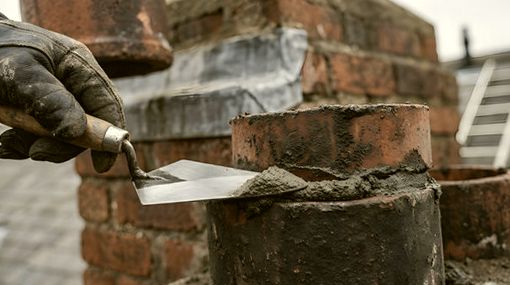 Trowel bedding fresh mortar at a crown